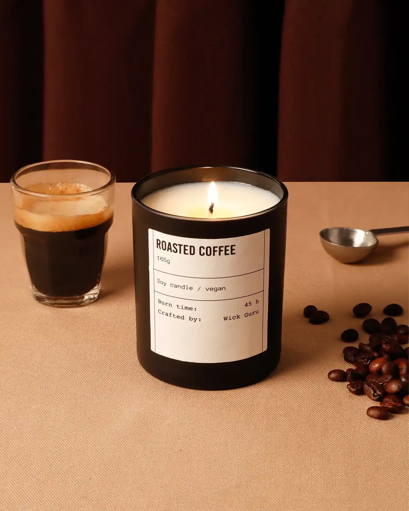 Roasted coffee candle with a glass of coffee on a brown surface