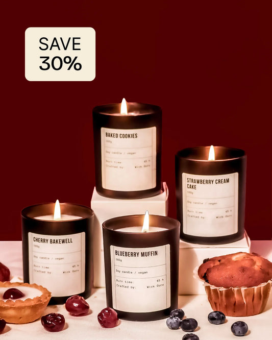 Candles with labels and muffins on a table against a red background