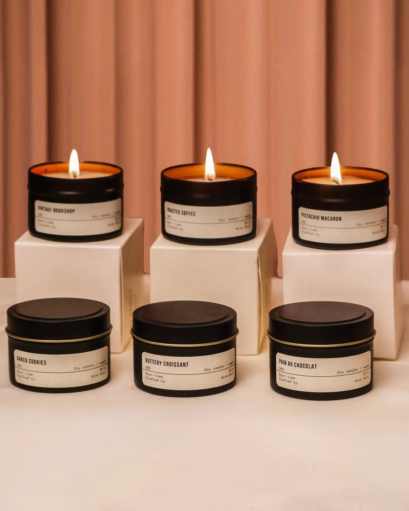 Set of bestselling tin candles with labels on a neutral background