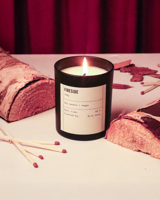 Fireside candle with matches on a surface with a red curtain background