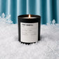 Candle labeled 'First Snowfall' in a snowy setting with snowflakes.