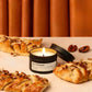 Candle labeled 'Maple Pecan Danish' with pastries and pecans on a neutral background