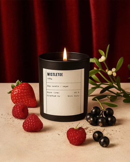 Candle labeled 'Mistletoe' with berries and leaves on a neutral background