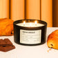 Candle labeled 'Pain au Chocolat' with croissants and chocolate bars on a white surface.