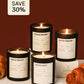 Set of candles with labels and croissants on a white surface against a brown background
