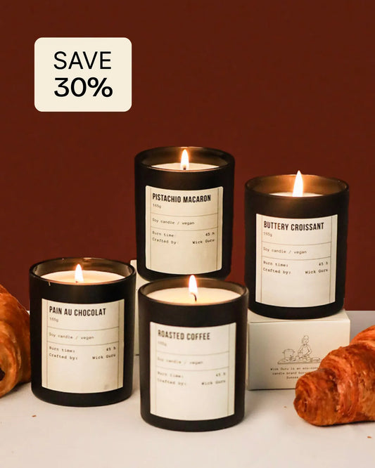 Set of candles with labels and croissants on a white surface against a brown background