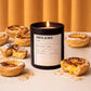 Candle labeled 'Pastel de Nata' surrounded by Portuguese pastries on a neutral background