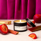 Candle with rhubarb and plum fragrance on a pink curtain background
