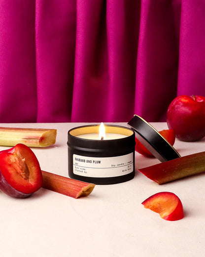 Candle with rhubarb and plum fragrance on a pink curtain background