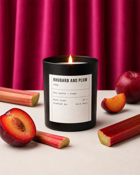 Candle labeled 'Rhubarb and Plum' with rhubarb and plum fruits on a pink curtain background