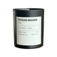 Candle labeled 'Pistachio Macaron' with black container and white label on a white background