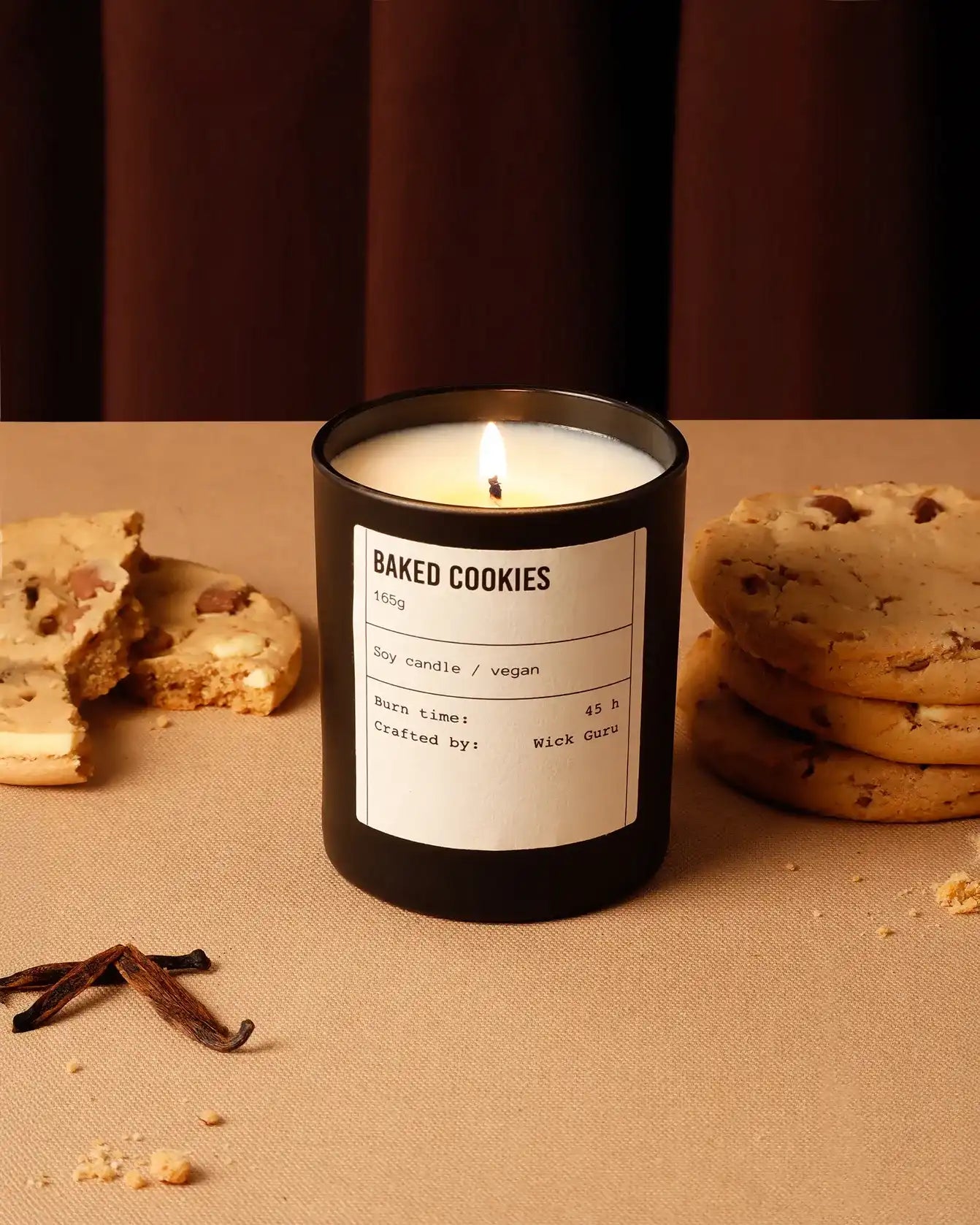 Candle labeled 'Baked Cookies' with cookies and vanilla beans on a brown surface