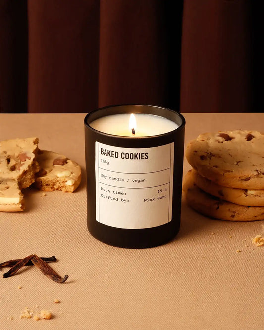 Candle labeled 'Baked Cookies' with cookies and vanilla beans on a brown surface