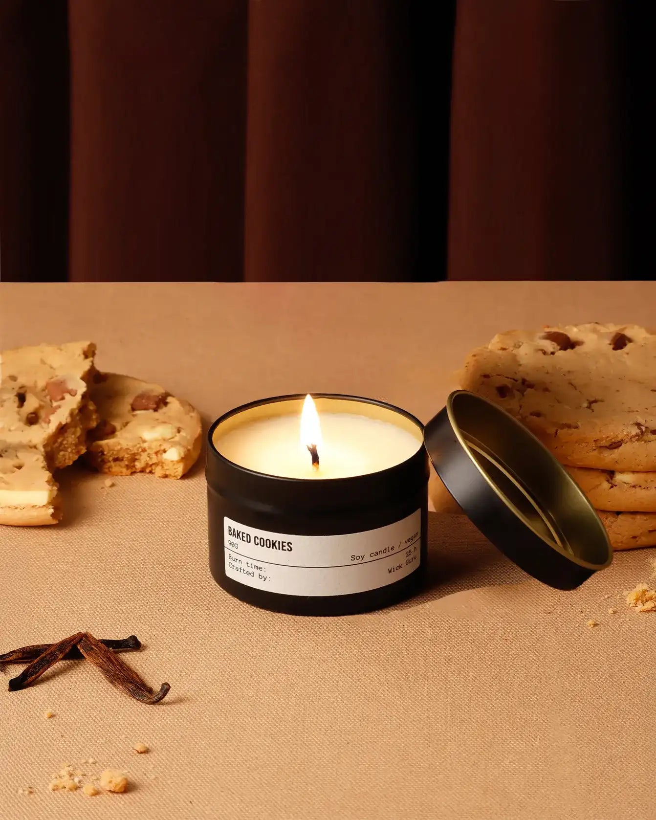 Candle labeled 'Baked Cookies' with cookies and vanilla beans on a brown surface