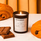 Candle labeled 'Pain au Chocolat' with chocolate bars and pastries on a white surface.