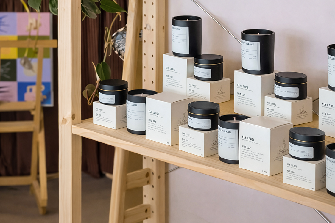Candles and boxes on a wooden shelf with a minimalistic design.